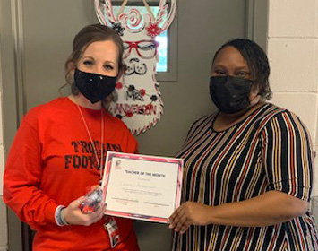 Laura Anderson, left, receives the high school teacher of the month award from Principal Elesha Buckley.