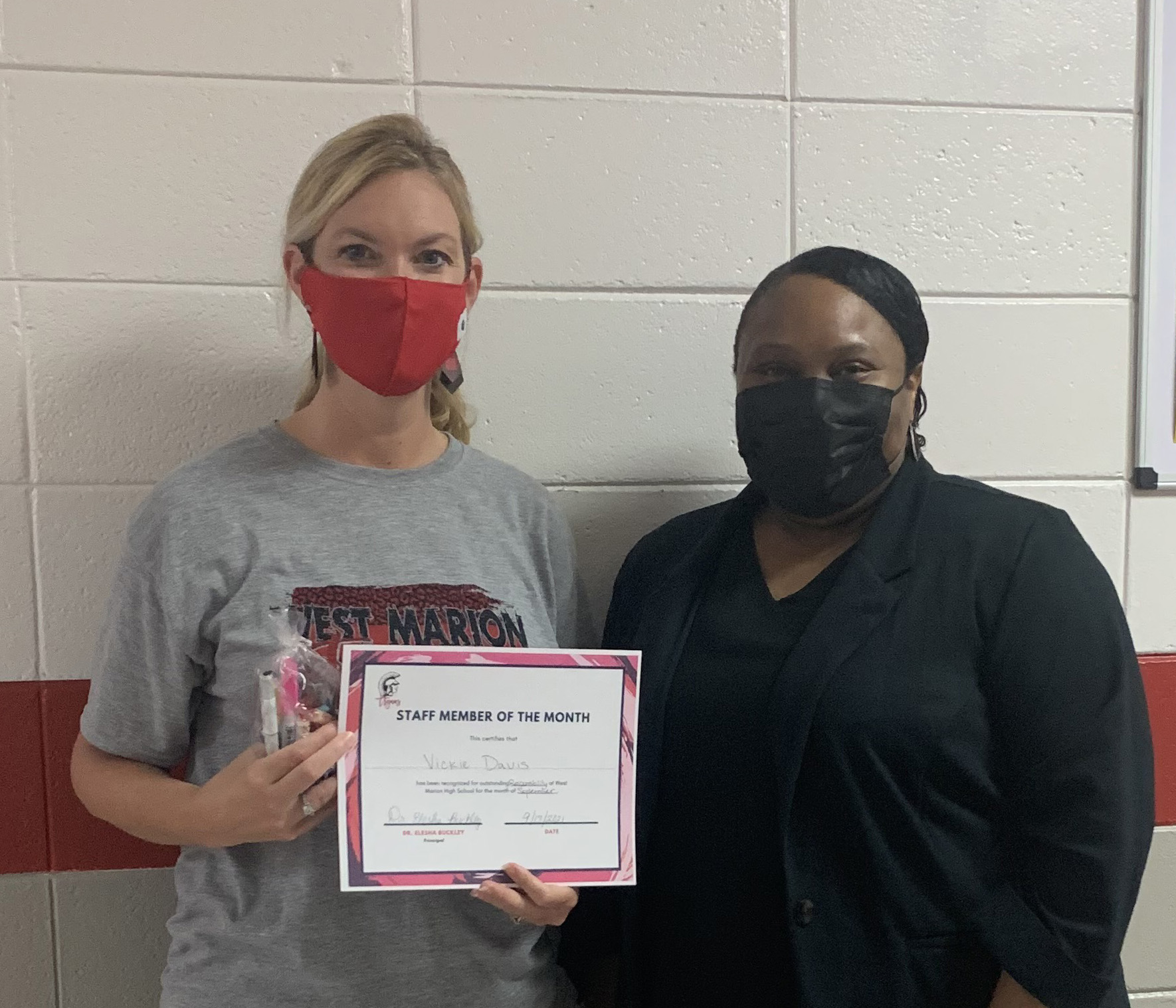 Vickie Davis, left, receives the staff member of the month award at West Marion High School from Principal Elesha Buckley.
