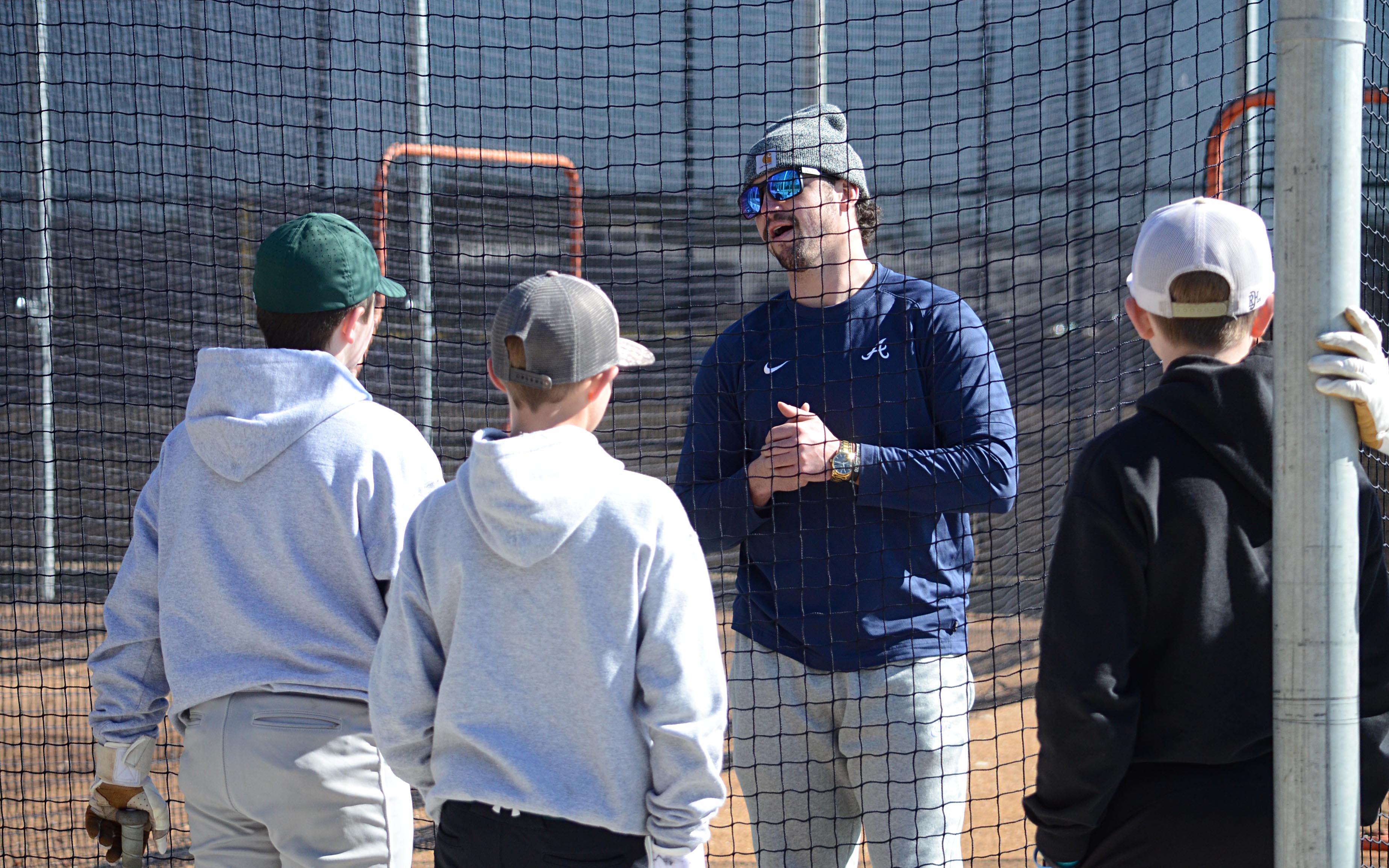 Brandon Parker Jr. instructs hitters in the batting cages.