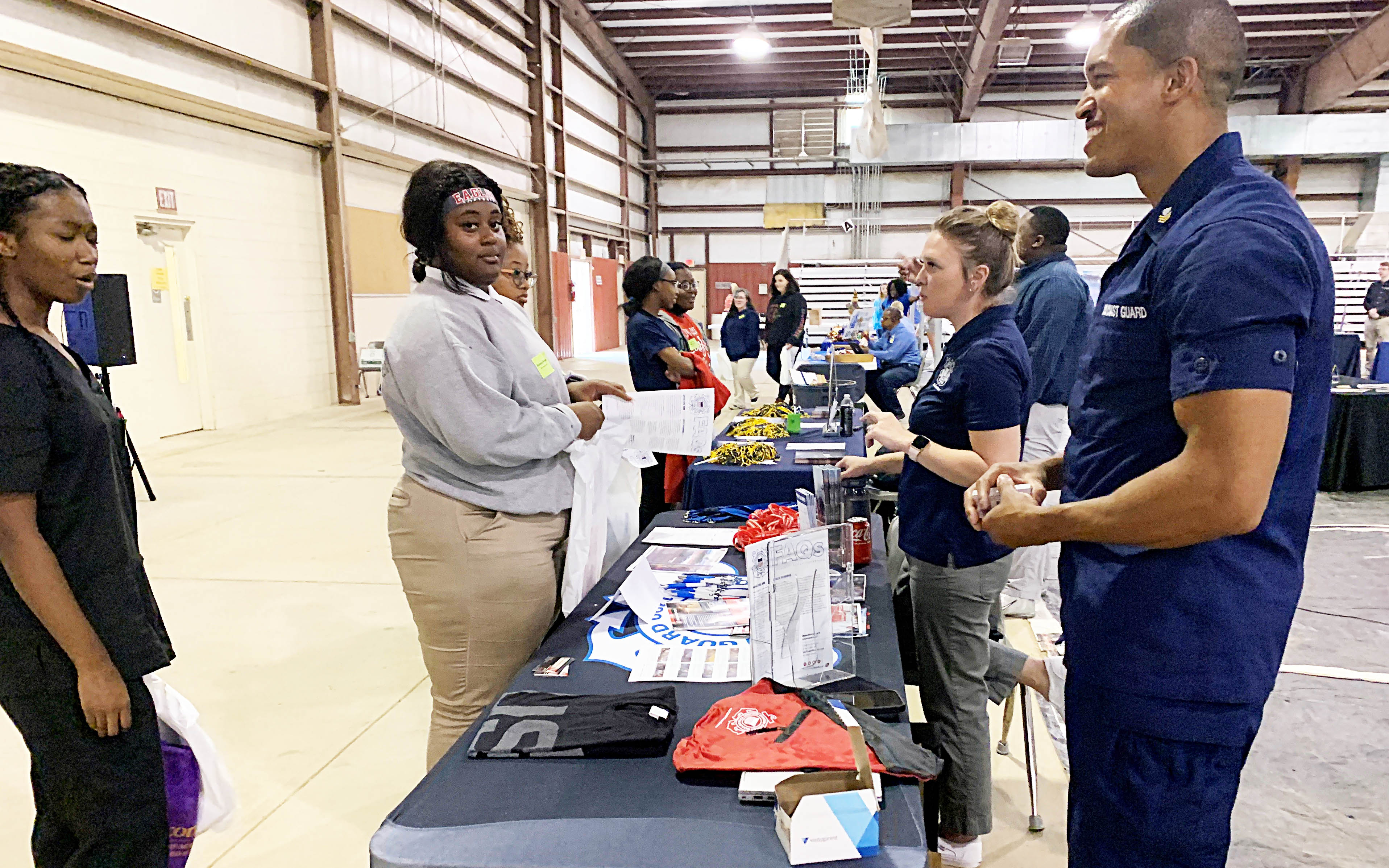 Anyla Jackson, Dalania Knight and Aubrey Harry of East Marion High School listen to United States Coast Guard recruiters.