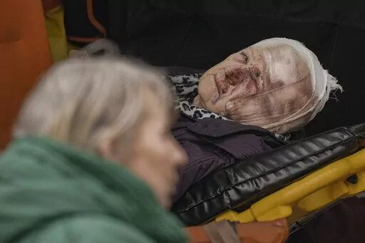 An injured woman evacuated from Irpin lies on a stretcher in an ambulance on the outskirts of Kyiv, Ukraine, Saturday, March 26, 2022. Russia continues to pound cities throughout Ukraine — explosions rang out Saturday near the western city of Lviv, a destination for refugees that has been largely spared from major attacks. (AP Photo/Vadim Ghirda)