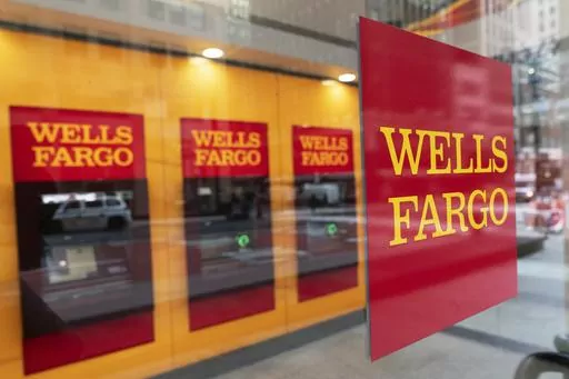 A Wells Fargo bank sign hangs outside a window on Jan. 13, 2021, in New York. A judge on Tuesday, May 16, 2023, granted preliminary approval of a deal under which Wells Fargo will pay $1 billion to settle a class-action lawsuit filed by shareholders. The shareholders alleged the bank made misleading statements about its compliance with federal regulators after a fake account-opening scandal that came to light in 2016. (AP Photo/Mark Lennihan, File)