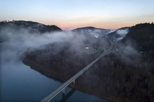 In this aerial image taken from a drone, the city of Klamath, Calif., home of the tribal headquarters for the Yurok Tribe, dots the side of U.S. Highway 101 at sunrise on Jan. 21, 2022. The Native American tribe has issued an emergency declaration on human trafficking and missing women. There have been five instances in the past 18 months where Indigenous women have gone missing or been murdered between San Francisco and the Oregon border. (AP Photo/Nathan Howard)