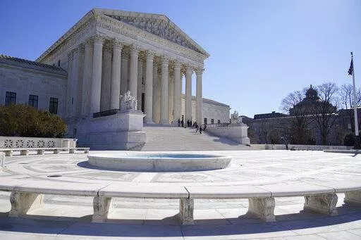 People stand on the steps of the U.S. Supreme Court, Feb.11, 2022, in Washington.  (AP Photo/Mariam Zuhaib, File)