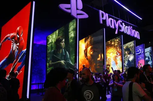 In this June 14, 2018 file photo people stand on a line next to the PlayStation booth at the Los Angeles Convention Center. PlayStation-maker Sony is escalating its competition with Xbox-maker Microsoft by buying the video game studio behind one of Xbox’s hit games. Sony Interactive Entertainment said Monday, Jan. 31, 2022 it would spend $3.6 billion to buy Bungie Inc., an independent game publisher based in Bellevue, Washington. (AP Photo/Damian Dovarganes, File)