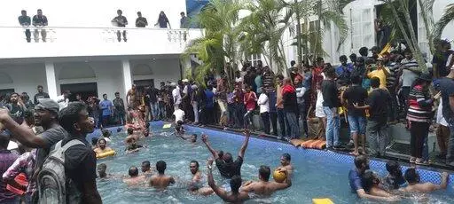 Anti government protesters swim in a swimmingpool of the Sri lankan president's official residence after storming into it in Colombo, Sri Lanka, Saturday, July 9, 2022. (AP Photo)