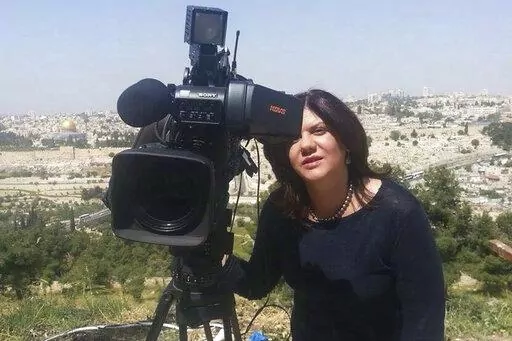 In this undated photo provided by Al Jazeera Media Network, Shireen Abu Akleh, a journalist for Al Jazeera network, stands next to a TV camera in an area where the Dome of the Rock shrine at Al-Aqsa Mosque in the Old City of Jerusalem is seen at left in the background. Abu Akleh, a well-known Palestinian female reporter for the broadcaster's Arabic language channel, was shot and killed while covering an Israeli raid in the occupied West Bank town of Jenin early Wednesday, May 11, 2022. (Al Jazee
