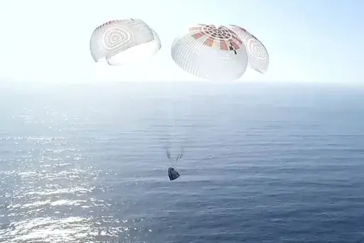In this image from video provided by SpaceX, a Dragon capsule carrying four space tourists prepares to splash down in the Pacific Ocean off the coast of California on Friday, April 4, 2025. (SpaceX via AP)