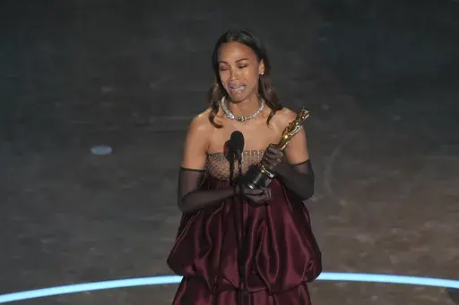 Zoe Saldana accepts the award for best performance by an actress in a supporting role for "Emilia Perez during the Oscars on Sunday, March 2, 2025, at the Dolby Theatre in Los Angeles. (AP Photo/Chris Pizzello)