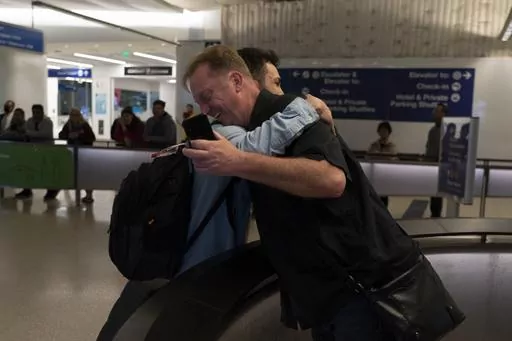 Michael White, a Navy veteran who was jailed in Iran for several years on spying charges, right, hugs Michael's former fellow prisoner and Iranian political activist Mahdi Vatankhah at the Los Angeles International Airport in Los Angeles, Thursday, June 1, 2023. Vatankhah, while in custody and after his release, helped White by providing White's mother with crucial, firsthand accounts about her son's status in prison and by passing along letters White had written while he was locked up. Once fre