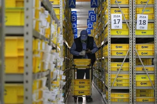 A worker collects parts at SMC, a Japanese pneumatic engineering company factory in Beijing on Jan. 10, 2023. China's trade surplus swelled to a record $877.6 billion in 2022 as exports rose 7% despite weakening U.S. and European demand and anti-virus controls that temporarily shut down Shanghai and other industrial centers. (AP Photo/Andy Wong)