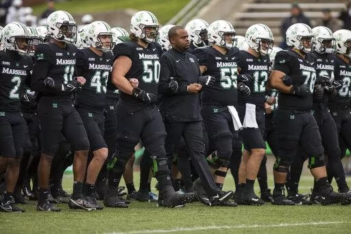 Marshall players and coaches take the field against UAB in an NCAA college football game on Saturday, Nov. 13, 2021, at Joan C. Edwards Stadium in Huntington W.Va. On Tuesday, March 29, 2022, Conference USA announced in a joint statement with Marshall, Old Dominion and Southern Miss that it has reached a resolution with the three schools to expedite their early move to the Sun Belt. (Sholten Singer/The Herald-Dispatch via AP, File)