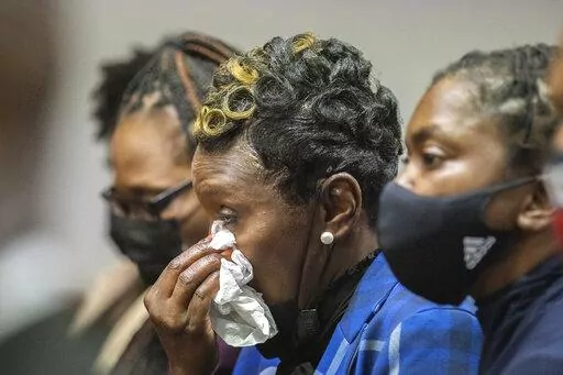 Ahmaud Arbery's mother Wanda Cooper-Jones, center, reacts as Superior Court Judge Timothy Walmsley sentences Greg McMichael, his son, Travis McMichael, and a neighbor, William "Roddie" Bryan in the Glynn County Courthouse, Friday, Jan. 7, 2022, in Brunswick, Ga. The three white men who chased and killed Ahmaud Arbery were sentenced Friday to life in prison, with a judge denying any chance of parole for the father and son who armed themselves and initiated the deadly pursuit of Arbery, a 25-year-