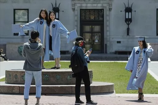 Columbia University class of 2020 graduates pose for photographs on Commencement Day on Wednesday, May 20, 2020, in New York. After three years, the pandemic-era freeze on student loan payments will end in late August. It might seem tempting to just keep not making payments, but the consequences can be severe, including a hit to your credit score and exclusion from future aid and benefits. (AP Photo/Frank Franklin II, File)