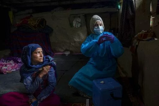 Masrat Farid, a healthcare worker, prepares to administer a dose of Covishield vaccine to Rubia Begum inside a hut during a COVID-19 vaccination drive in Gagangeer, northeast of Srinagar, Indian controlled Kashmir on June 22, 2021. Farid has traveled long distances to vaccinate mostly shepherds and nomadic herders in the remote meadows of the Himalayan region of Indian-controlled Kashmir. (AP Photo/Dar Yasin)