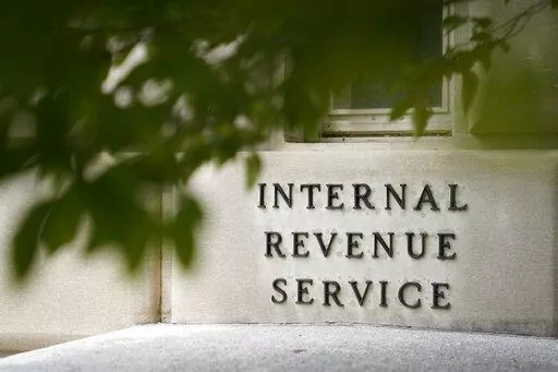 A sign is displayed outside the Internal Revenue Service building on May 4, 2021, in Washington. Conservative politicians and candidates are distorting how a major economic bill passed over the weekend by the Senate would reform the IRS and affect taxes for the middle class. The Inflation Reduction Act, which awaits a House vote after passing in the Senate on Sunday, would increase the ranks of the IRS — but it wouldn’t create a mob of armed auditors looking to harass middle class taxpayers,