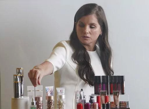 Revlon CEO Debra Perelman, the company's first woman CEO in its 89-year-old history, show products during an interview, Wednesday Aug. 18, 2021, in New York. Revlon, the 90-year-old multinational beauty company, has filed for Chapter 11 bankruptcy protection, Thursday, June 16, 2022, weighed down by debt load, disruptions to its supply chain network and surging costs.  (AP Photo/Bebeto Matthews, File)