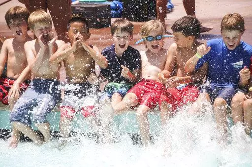 The photo released by the American Camp Association shows young boys splashing at the Tom Sawyer Camp pool in Pasadena, Calif., on July 11, 2019. After two pandemic summers, many families are venturing back into what they hope will be a more normal summer-camp experience. (Lisa Phelan/American Camp Association via AP)