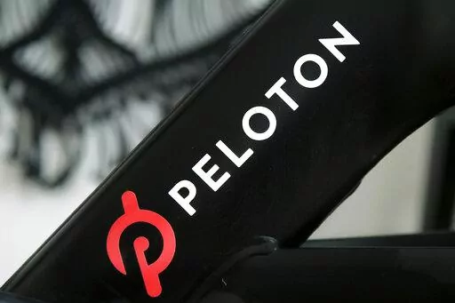 A Peloton logo is seen on the company's stationary bicycle on Nov. 19, 2019, in San Francisco. Peloton is laying off employees and raising prices for some of its equipment as part of its latest bid to make the business profitable and free up cash, according to a memo disclosed to employees on Friday, Aug. 12, 2022. (AP Photo/Jeff Chiu, File)