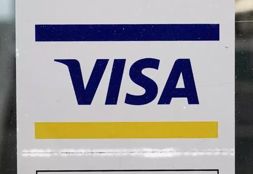 A Visa sign is displayed on the front door of a local business, April 27, 2021, in Urbandale, Iowa. Visa has announced major changes to how its credit and debit cards will operate in the U.S. Features in the works will lead to Americans to carry fewer physical cards in their wallets and make the 16-digit credit or debit card number printed on every physical card increasingly irrelevant. The new features unveiled Wednesday, May 15, 2024 will be some of the biggest changes to how payments operate 