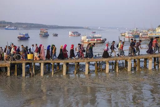 Workers walk to work at an export processing zone early in the morning after crossing the Mongla river in Mongla, Bangladesh, March 3, 2022. This Bangladeshi town stands alone to offer new life to thousands of climate migrants. (AP Photo/Mahmud Hossain Opu, File)
