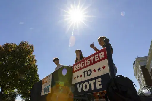James Galvin, Ella Nelsen and Charlotte Papacosma register students to vote at the University of Virginia in Charlottesville, Va., Friday, Oct. 11, 2024. (AP Photo/Ryan M. Kelly)