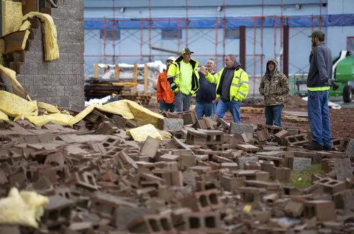 Stewart Richey Electrical employees and other utility workers and city crews survey and help clear debris at Thornton Furniture on Cave Mill Road in Bowling Green, Ky., after another tornado warning was issued, Saturday, Jan. 1, 2022, for Warren and surrounding counties, following the devastating tornadoes that tore through town on Dec. 11, 2021. Though the damage from Saturday's storm proved less catastrophic than the system that passed through in December, heavy rain and strong winds battered 