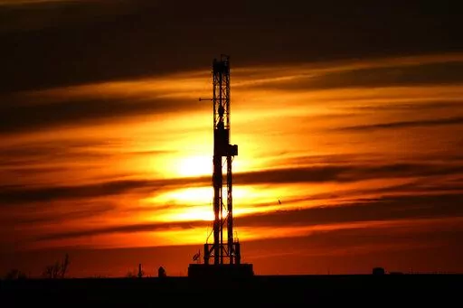 An oil drilling rig is pictured at sunset, Monday, March 7, 2022, in El Reno, Okla. A federal appeals court in New Orleans hears arguments Tuesday, May 10, 2022, about whether President Joe Biden legally suspended new oil and gas lease sales because of climate change worries. (AP Photo/Sue Ogrocki, File)