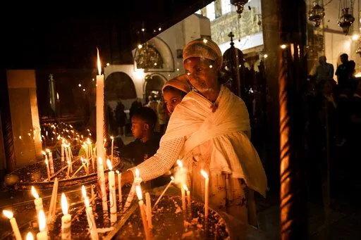 An Ethiopian woman and her child visit the Church of the Nativity, traditionally believed to be the birthplace of Jesus Christ, in the West Bank town of Bethlehem, Saturday, Dec. 3, 2022. Business in Bethlehem is looking up this Christmas as the traditional birthplace of Jesus recovers from a two-year downturn during the coronavirus pandemic. Streets are already bustling with visitors, stores and hotels are fully booked and a recent jump in Israeli-Palestinian fighting appears to be having littl