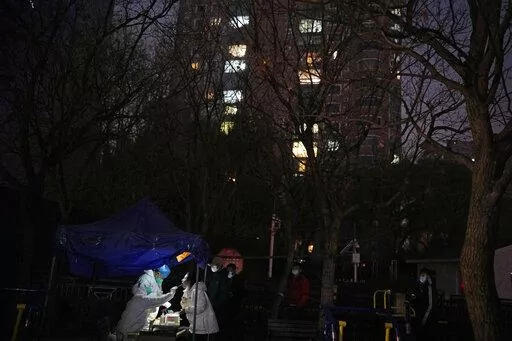 A resident gets swabbed for the COVID test outside a neighborhood in Beijing, Saturday, Nov. 19, 2022. (AP Photo/Ng Han Guan)