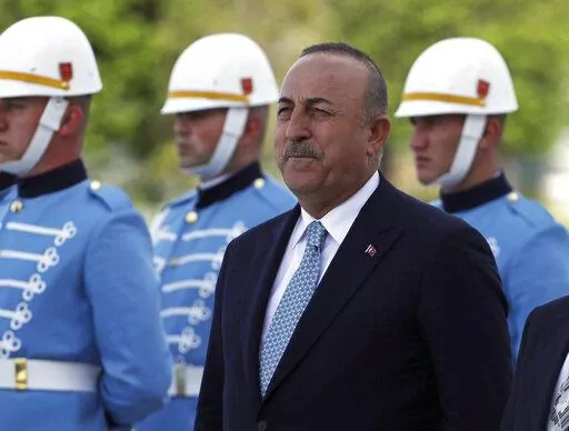 Turkish Foreign Minister Mevlut Cavusoglu stands with a military honour guard, in Ankara, Turkey, Wednesday, June 1, 2022. Cavusoglu sent a letter to the U.N. formally requesting that his country be referred to as "Türkiye," the state-run news agency reported. The move is seen as part of a push by Ankara to rebrand the country and dissociate its name from the bird, turkey, and some negative connotations that are associated with it. Anadolu Agency said Stephane Dujarric, spokesman to U.N. Secret