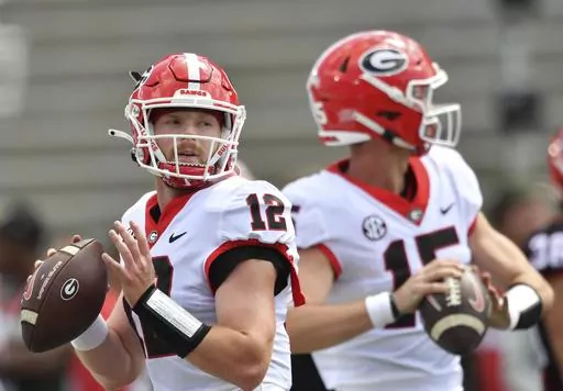 Georgia quarterbacks Brock Vandagriff (12) and Carson Beck (15) warm up before the G - Day spring football game at Sanford Stadium, Saturday, April 15, 2023, in Athens, Ga. Beck has attempted 58 passes over the past three seasons. Third-year player Brock Vandagriff was a five-star recruit. (Hyosub Shin/Atlanta Journal-Constitution via AP, File)