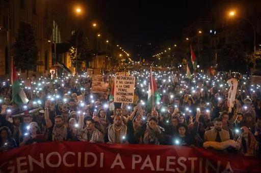 Demonstrators use the flashlights on their mobile phones as they protest against Israeli attacks on Gaza, in Barcelona, Spain on Nov. 11, 2023. (AP Photo/Emilio Morenatti, File)