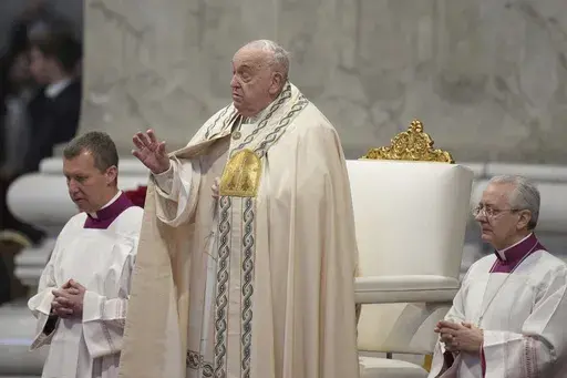 Pope Francis is flanked by Vatican Head Master of Ceremonies, Bishop Diego Giovanni Ravelli, right, and Master of Ceremonies, Bishop Krysztof Marcjanowicz as he presides over a mass in St. Peter's Basilica at The Vatican on New Year's Day, Wednesday, Jan. 1, 2025. (AP Photo/Andrew Medichini)