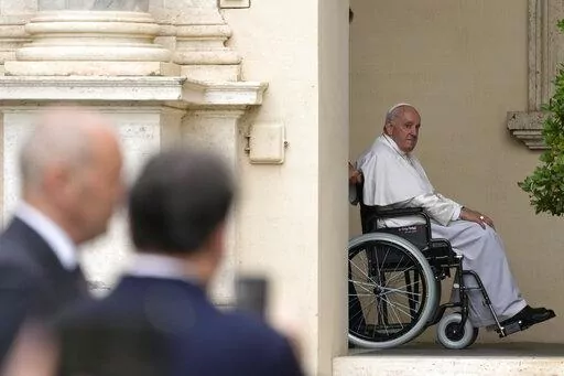 Pope Francis arrives on a wheelchair for an audience with children in the San Damaso courtyard at the Vatican, Saturday, June 4, 2022. Pope Francis added fuel to rumors about the future of his pontificate on Saturday by announcing he would visit the central Italian city of L'Aquila in August for a feast initiated by Pope Celestine V, one of the few pontiffs who resigned before Pope Benedict XVI stepped down in 2013. (AP Photo/Alessandra Tarantino, File)