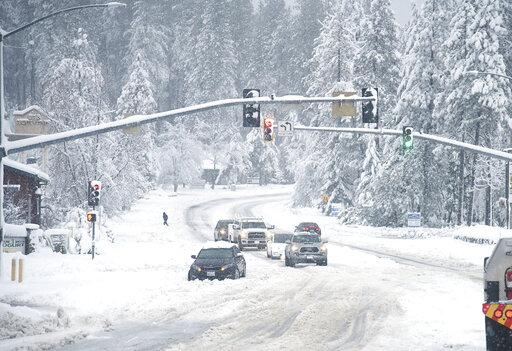 A vehicle is stuck in the snow along Brunswick Road and Sutton Way Monday morning, Dec. 27, 2021, in Grass Valley, Calif. (Elias Funez/The Union via AP)