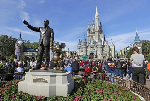 A statue of Walt Disney and Micky Mouse stands in front of the Cinderella Castle at the Magic Kingdom at Walt Disney World in Lake Buena Vista, Fla., Jan. 9, 2019. Tens of thousands of LGBTQ+ people are flocking to Florida's theme parks and hotels to go on thrill rides, dance at all-night parties and lounge poolside in a decades-long tradition known as Gay Days. Even though Gov. Ron DeSantis and Florida lawmakers have championed a slew of anti-LGBTQ laws, that's not stopping organizers from enco