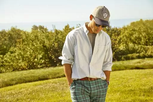 This photo provided by Brooks Brothers shows a model showing a Brooks Brothers casual office wardrobe.  Going back to the office, many don't want to return to structured looks like suits,  zip-front pants and pencil skirts from the pre-pandemic days. But they also don't want to look unprofessional. So they're experimenting with new approaches, forcing retailers and clothing brands to respond with colorful  blazers in knit or sweatshirt fabrics,  pants with drawstrings or elastic bands, and new c