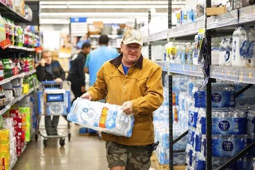 John Beezley, of Bonham, buys cases of water after learning that a boil water notice was issued for the entire city of Houston on Sunday, Nov. 27, 2022, at Walmart on S. Post Oak Road in Houston. Beezley just arrived in town with his wife, who is undergoing treatment starting tomorrow at M.D. Anderson Cancer Center, where they are staying in a camping trailer. They turned on the television after settling in and saw that a boil water notice had been issued. Beezley decided to go out immediately f