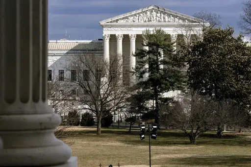 The Supreme Court is seen in the distance, framed through columns of the U.S. Senate at the Capitol in Washington, Feb. 20, 2025. (AP Photo/J. Scott Applewhite, File)