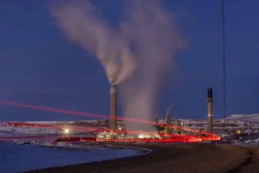 In this photo taken with a slow shutter speed, taillights trace the path of a motor vehicle at the Naughton Power Plant, Thursday, Jan. 13, 2022, in Kemmerer, Wyo. While the power plant will be closed in 2025, Bill Gates' company TerraPower announced it had chosen Kemmerer for a nontraditional, sodium-cooled nuclear reactor that will bring on workers from a local coal-fired power plant scheduled to close soon. The U.S. nuclear industry has provided a steady 20% of the nation's power for years, b