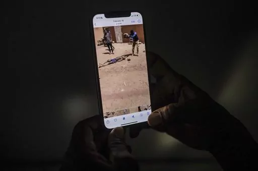 EDS NOTE: GRAPHIC CONTENT - An uncle of a 16-year-old named Adama watches a video in Burkina Faso, Saturday March 18, 2023, showing a man slamming a rock onto the head of his nephew. Burkina Faso has been wracked by violence linked to al-Qaida and the Islamic State group that has killed thousands, but some civilians say they are even more afraid of Burkina Faso’s security forces, whom they accuse of extrajudicial killings. The military junta has denied its security forces were involved, but a 