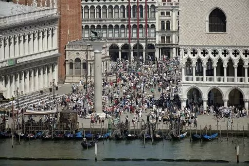 A view of the St. Mark's Square in Venice, Italy, taken on June 8, 2019. Venice authorities have rolled out a pilot program to charge day-trippers 5 euros ($5.45) apiece to enter the fragile lagoon city on peak weekends next year. The aim is to reduce crowds, encourage longer visits and improve the quality of life for residents. (AP Photo/Luca Bruno, File)