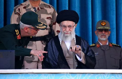 In this picture released by the official website of the office of the Iranian supreme leader, Supreme Leader Ayatollah Ali Khamenei, center, listens to chief of the General Staff of the Armed Forces Gen. Mohammad Hossein Bagheri at a graduation ceremony for a group of armed forces cadets at the police academy in Tehran, Iran, Monday, Oct. 3, 2022. Khamenei responded publicly on Monday to the biggest protests in Iran in years, breaking weeks of silence to condemn what he called “rioting” and 