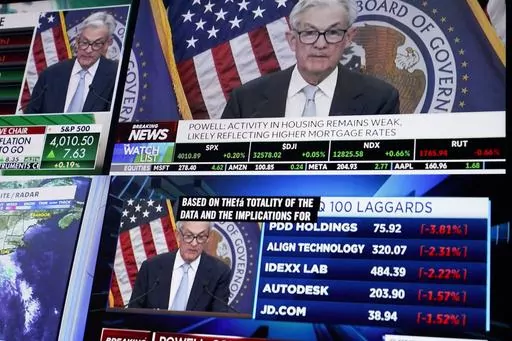 Displays show Fed chairman Jerome Powell's news conference while traders work on the floor at the New York Stock Exchange in New York, Wednesday, March 22, 2023. (AP Photo/Seth Wenig)