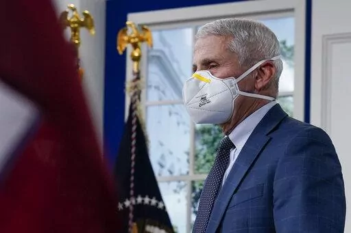 Dr. Anthony Fauci, the top U.S. infectious disease expert, wears a face mask as he arrives for the the White House COVID-19 Response Team's regular call with the National Governors Association in the South Court Auditorium in the Eisenhower Executive Office Building on the White House Campus, Monday, Dec. 27, 2021, in Washington. Fauci says the U.S. should consider a vaccination mandate for domestic air travel as coronavirus infections surge. To date the Biden administration has balked at the id
