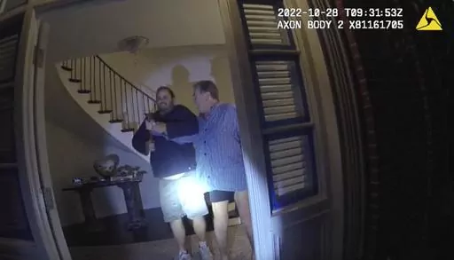 In this image taken from San Francisco Police Department body-camera video, the husband of former U.S. House Speaker Nancy Pelosi, Paul Pelosi, right, fights for control of a hammer with his assailant David DePape during a brutal attack in the couple's San Francisco home on Oct. 28, 2022. Opening statements are scheduled for Thursday, Nov. 8, 2023, in the federal trial of the man accused of breaking into former House Speaker Nancy Pelosi's San Francisco home seeking to kidnap her and bludgeoning