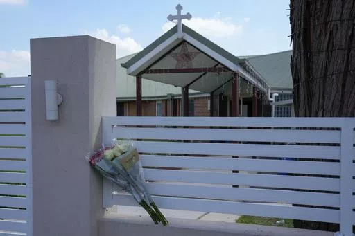 Flores sit on a fence outside the Christ the Good Shepherd church in suburban Wakely in western Sydney, Australia, on April 16, 2024. Detectives and secret service agents investigating the stabbing of a bishop in the Sydney church last week executed search warrants in the city on Wednesday, April 24, as part of a major operation, officials said. (AP Photo/Mark Baker, File)