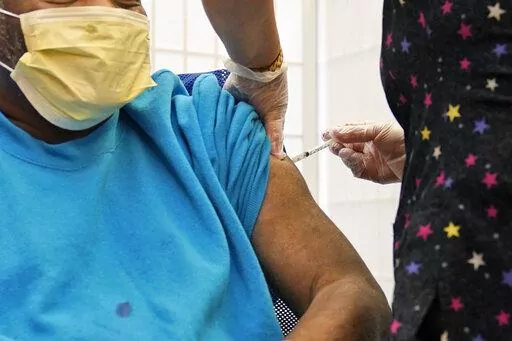 A 62-year-old nursing home resident receives a COVID-19 booster shot in New York on Monday, Sept. 27, 2021. A study released on Wednesday, Jan. 19, 2022 that compares coronavirus protection from prior infection and vaccination in New York and California concludes getting the shots is still the safest way to prevent COVID-19. (AP Photo/Seth Wenig, File)