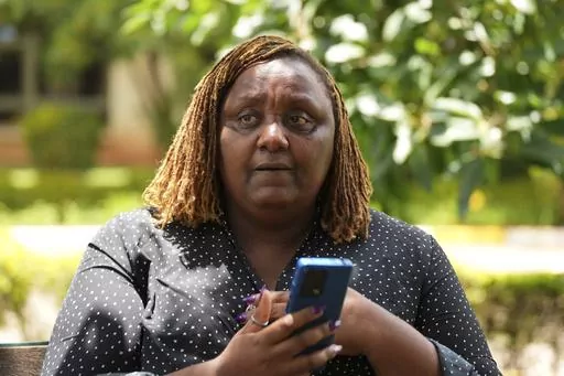 Njeri Migwi, a woman human rights defender and the Co-Founder of Usikimye (Swahili word for 'Don't be Silent'), an organization working towards ending the prevalence of sexual and gender-based violence (GBV) holds her phone in downtown Nairobi, Kenya, Wednesday, March 6, 2024. Migwi, is on the frontline of a war against a silent epidemic of Gender Based Violence or GBV in Kenya that also afflicts many Sub-Saharan African countries, with devasting consequences on individuals, societies and even t